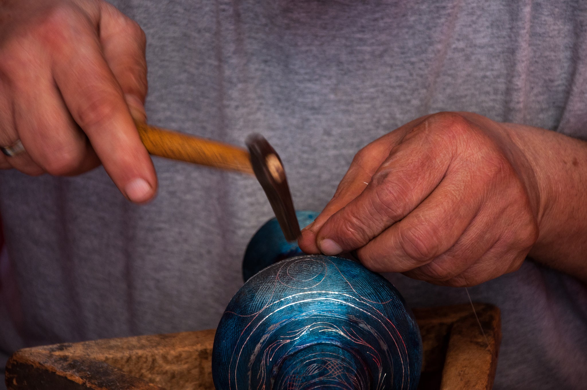 Damascene Artisan hammering silver thread into metal